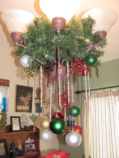 a christmas tree with ornaments hanging from it's branches and lights on the ceiling