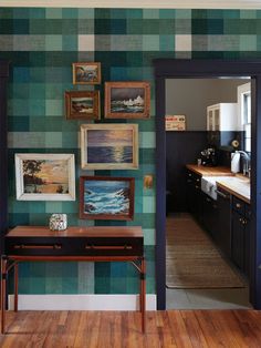 an open door leading to a kitchen with green and blue wallpaper