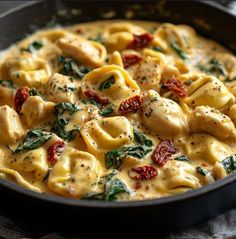 a skillet filled with pasta and spinach