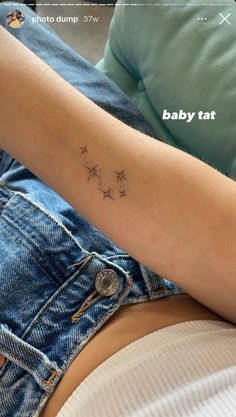 a woman's arm with stars on it and the word baby tat written in cursive font