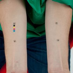 two people with matching tattoos on their arms, both showing the same color and number