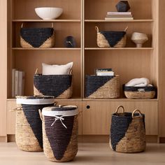 three baskets are sitting on the floor in front of a bookshelf and shelves