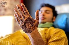 a man is holding his hand up to show the hendi design on his palm