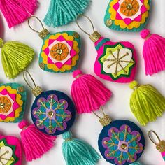 colorful tasselled ornaments are arranged on a white surface