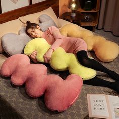 a woman laying on top of a bed next to three stuffed animals