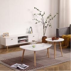 two white tables sitting on top of a wooden floor