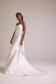 a woman in a white wedding dress posing for a photo with her hands on her hips