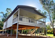 a two story house sitting on top of a lush green field