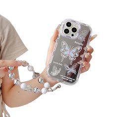 a woman holding a cell phone case with butterflies on it and chains around her arm