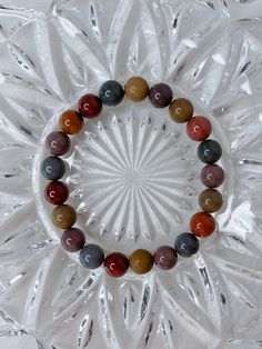 "You will receive one stunning, high quality Alashan Agate bracelet. A natural mix of warm, rainbow colours. This beaded crystal bracelet is made \"one size\", and stretches to fit. It measures roughly 6.75 cm in diameter, and the beads measure 9mm. * * * * * ABOUT ALASHAN AGATE: Alashan agate is a type of agate that is known for its unique patterns and colors. It is a semi-precious gemstone that is found in the Alxa League of Inner Mongolia, China.  Yanyuan agate, named after Yanyuan County in Sichuan, China, is a variety of banded chalcedony, a mineral of the quartz family. They are known for their diverse and striking colors, usually forming in volcanic rocks or limestones. ❀ * * * * * Follow me on Instagram: instagram.com/ambers.expressions" Multicolor Crystal Bracelet With Round Natural Stones, Multicolor Agate Crystal Bracelet With Round Beads, Multicolor Agate Stretch Bracelet With Natural Stones, Multicolor Agate Beaded Bracelets, Multicolor Agate Beaded Bracelet, Multicolor Agate Beaded Bracelets With Round Beads, Multicolor Agate Bracelet With Natural Stones, Rainbow Crystal Bracelet With Natural Stone Round Beads, Multicolor Agate Hand-strung Crystal Bracelet