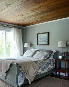 a large bed sitting under a wooden ceiling