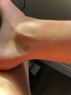 a person with a small sun tattoo on their arm