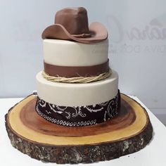 a three tiered cake with a cowboy hat on top