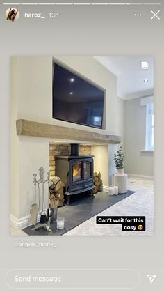 a fireplace with a tv above it and some logs on the floor in front of it