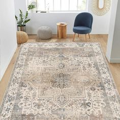 a large rug with an ornate design on the floor in front of a blue chair