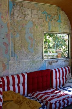 a red, white and blue couch sitting in front of a map on the wall