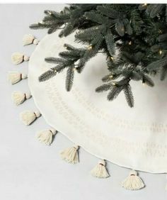 a christmas tree skirt with tassels on it