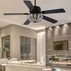 a living room with white furniture and a chandelier hanging from the ceiling,