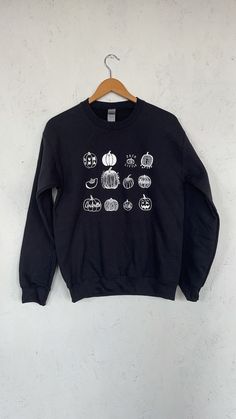 "This listing is for a unisex sweatshirt screen printed with a variety of hand drawn pumpkins. Perfect for halloween! It is shown here printed with white ink on a black sweatshirt. // PROCESS: All of our items are individually hand printed by either me or my dad, which can lead to slight variations in placement. The ink is heat cured and will not fade over time. Since our items are printed to order, there is a 1-2 week processing time before shipping. If you absolutely need an item shipped quick Spooky Black Sweatshirt With Graphic Print, Fall Black Sweatshirt With Custom Print, Fall Black Sweatshirt With Screen Print, Black Screen Print Sweatshirt For Fall, Black Top With Custom Print For Fall, Halloween White Screen Print Sweatshirt, Custom Print Sweatshirt For Fall Streetwear, Sweatshirts Cricut, Pumpkin Sweatshirt