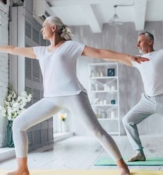 two people are doing yoga in a room