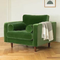 a green chair sitting on top of a hard wood floor next to a white wall