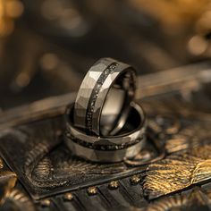 two wedding rings sitting on top of each other