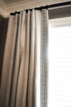 a curtain with greek border hanging in front of a window