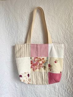 a multicolored patchwork tote bag hanging on a wall