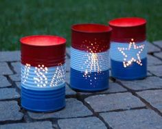 three red, white and blue plastic cups sitting on top of a brick floor next to grass