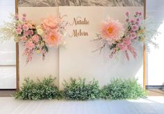 flowers are arranged on the side of a wall with nameplates and names written on it