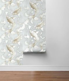 the wall paper is decorated with gold fish and waves on grey background, along with wood flooring