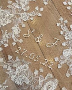 white lace on wood floor with flowers and letters that spell out the word love written in it