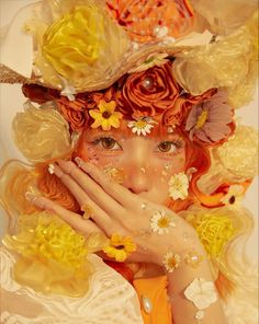 a woman with orange hair and flowers on her head is covering her face while holding her hands to her mouth