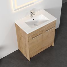 a white sink sitting under a mirror next to a wooden cabinet in a room with grey flooring