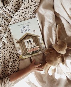 a child is laying in bed with a book about the story of lato stinky