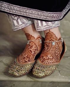 a woman's feet with hennap and shoes on top of her legs