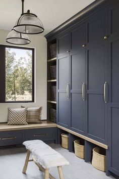 a room with blue cabinets and a bench