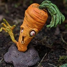 a close up of a toy carrot on a rock