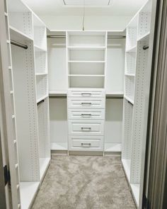 an empty walk in closet with lots of drawers and white shelving unit doors open