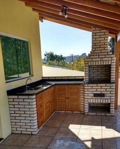 an outdoor kitchen area with tile flooring and wooden cabinets on either side of the oven