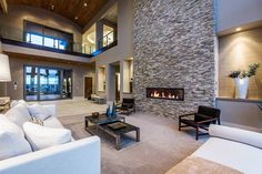 a living room with white couches and a fire place in the middle of it