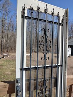 an iron gate is seen through the glass on this house's front door, with benches and picnic tables in the background