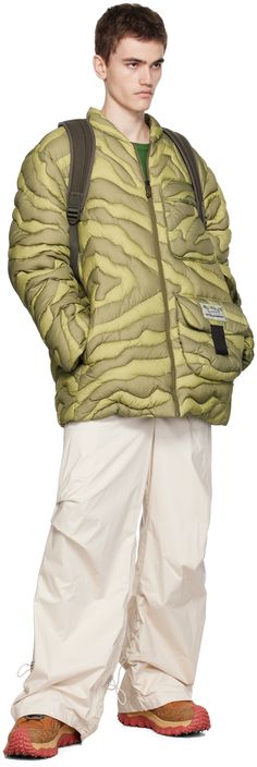 DIST-certified down-filled quilted nylon ripstop jacket. Graphic pattern throughout. · Stand collar · Zip closure · Flap pockets and seam pockets · Logo patches at front · Text embroidered at back · Nylon longue saison lining Part of the Moncler x Salehe Bembury collection. Supplier color: Green Fill: 90% goose down, 10% goose feather. Green Puffer Jacket With Pockets For Outdoors, Green Quilted Jacket With Pockets For Outdoor, Outdoor Nylon Quilted Jacket With Pockets, Outdoor Quilted Nylon Jacket With Pockets, Quilted Nylon Long-sleeved Parka, Quilted Nylon Parka With Long Sleeves, Green Down Puffer Jacket With Pockets, Long Sleeve Nylon Puffer Jacket With Pockets, Outdoor Nylon Outerwear With Patch Pockets