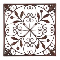 a decorative metal wall decoration with leaves and berries on the center, in an ornate design