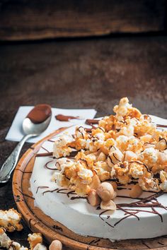 a cake covered in chocolate and marshmallows on top of a wooden plate