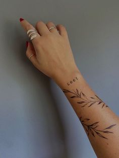 a woman's hand with a small tattoo on her left wrist and the word eat written in cursive writing