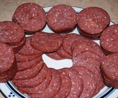 a white plate topped with meat patties on top of a wooden table