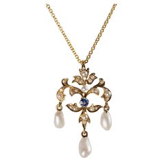 This lovely & dainty pendant features 26 tiny natural half-round river pearls set into a quintessentially Art Nouveau mounting of 14k yellow gold in a foliate motif, with three dangling tear-shaped pearls. In the center of this striking pendant is a vivid blue natural and unheated Yogo sapphire from Montana. Though the tiny sapphire measures just shy of 1/10th of a carat, it is such an open, bright blue that it immediately draws the eye. The pendant measures approximately 31mm x 18mm and the included 14K chain is 18" in length. This lovely Art Nouveau pendant ships with a certificate from Stone Group Labs stating that the sapphire is untreated and is from the Yogo Gulch in Montana. Yogo Sapphire, Art Deco Pendant Necklace, Drop Necklaces, Vintage Assemblage Jewelry, River Pearls, Art Nouveau Pendant, Pearl Drop Necklace, Dainty Pendant, Assemblage Jewelry