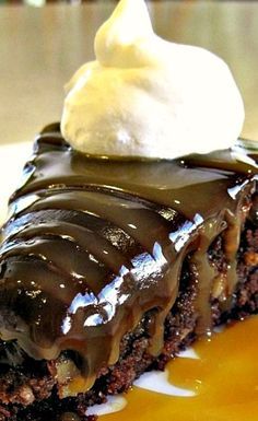 a piece of chocolate cake with ice cream on top and caramel sauce drizzled over it