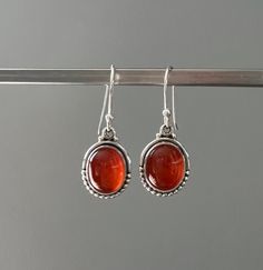 Gift box available for purchase. Search GIFTBOXSterling silver Carnelian teardrop earrings, deep orange colour, 925 sterling silver, birthstone of August. Carnelian is a stabilising stone, restores vitality and motivation, stimulates creativity, gives courage, promotes positive life choices, helps you trust in your perceptions and in yourself. A gift for her for any occasion. Your earrings will be presented in our funky drawstring bags. Amber Carnelian Gemstone Earrings, Carnelian Teardrop Earrings For Gift, Cabochon Amber Earrings For Gift, Carnelian Amber Earrings For Gift, Amber Cabochon Earrings Gift, Amber Cabochon Earrings For Gifts, Amber Carnelian Earrings Gift, Carnelian Drop Earrings Jewelry Gift, Orange Carnelian Earrings For Gift